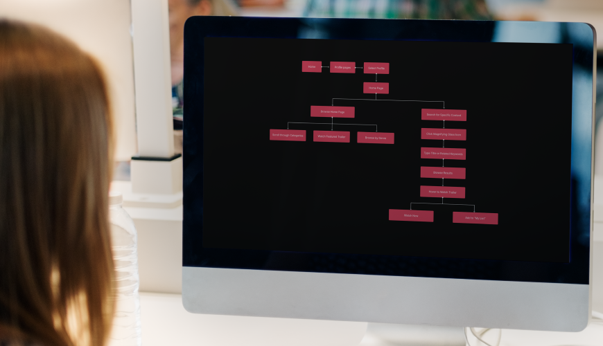 A woman examines a computer screen displaying a tree diagram related to information architecture.