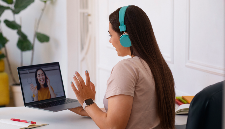 A woman in headphones engages in a video call, showcasing effective UX research methods in digital communication.